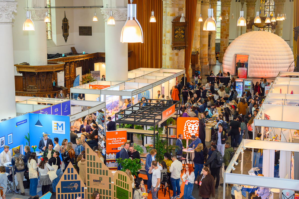 IamExpat Fair Den Haag 2026 in de Grote Kerk met bezoekers en exhibitiestands